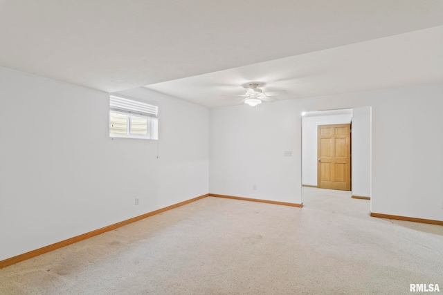 spare room with baseboards, light colored carpet, and ceiling fan