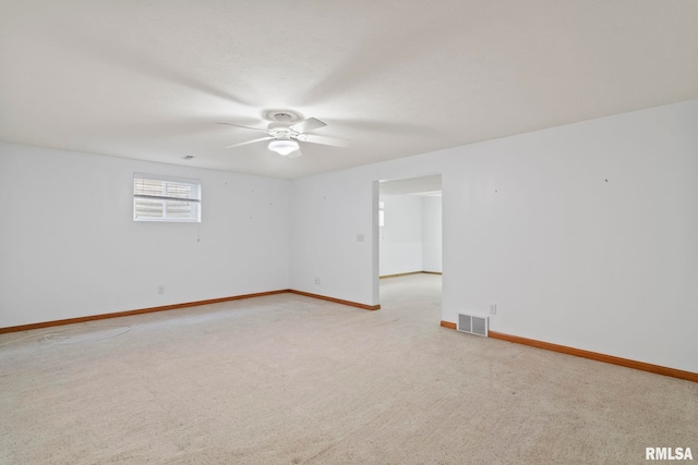 unfurnished room featuring visible vents, baseboards, light colored carpet, and a ceiling fan