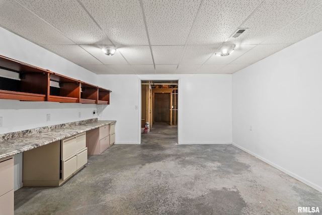 interior space with visible vents, baseboards, and a drop ceiling