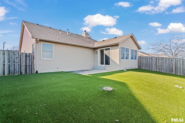 back of house with a patio, a lawn, a fenced backyard, and a chimney