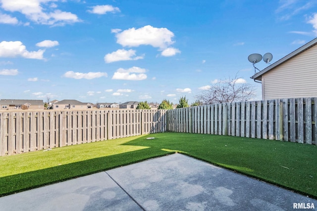 view of yard featuring a residential view, a fenced backyard, and a patio area