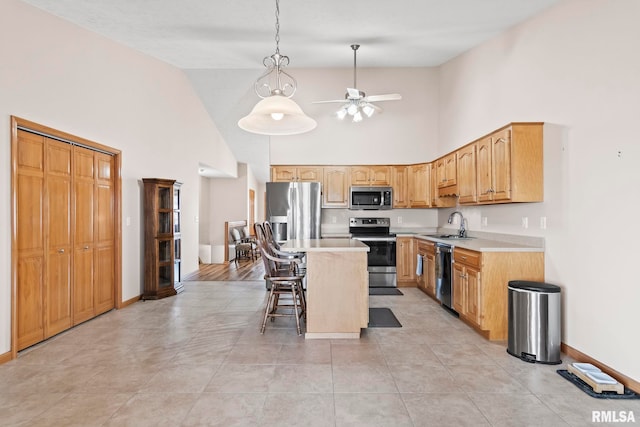 kitchen with ceiling fan, light countertops, a sink, and stainless steel appliances