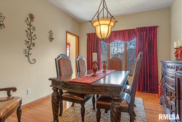 dining space with baseboards and light wood-style floors