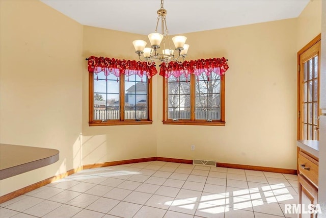 unfurnished dining area with a notable chandelier, light tile patterned floors, baseboards, and visible vents