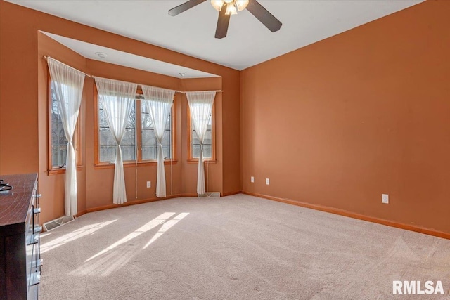 carpeted spare room with baseboards and ceiling fan