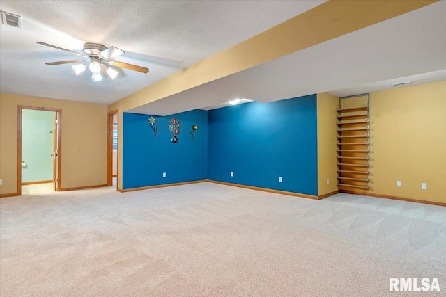 carpeted spare room with a ceiling fan, baseboards, visible vents, and a textured ceiling