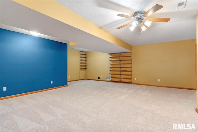 below grade area with visible vents, baseboards, carpet, and ceiling fan