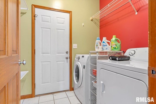 washroom featuring laundry area, light tile patterned floors, and washing machine and clothes dryer