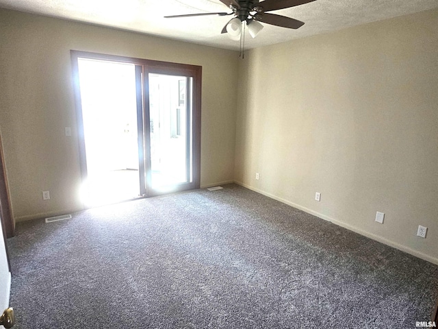 unfurnished room with carpet, a ceiling fan, visible vents, and baseboards