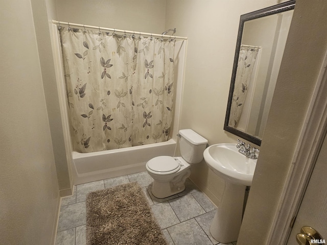 bathroom featuring toilet, shower / tub combo with curtain, and a sink