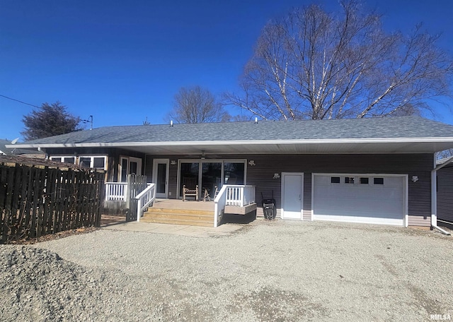 ranch-style home with driveway, a porch, fence, a shingled roof, and a garage