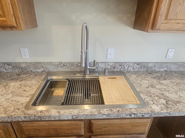 details with light countertops, brown cabinets, and a sink