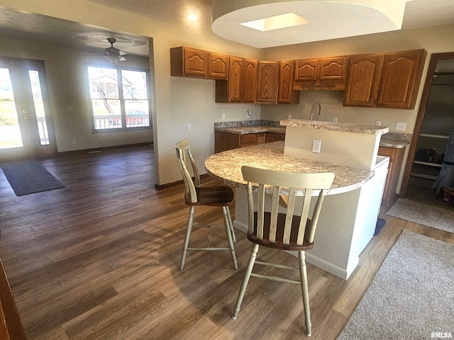 kitchen with light countertops, baseboards, and dark wood-style flooring