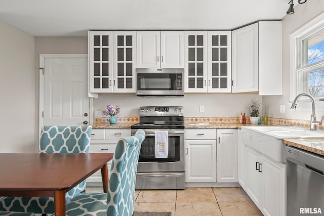 kitchen featuring a sink, appliances with stainless steel finishes, and white cabinets