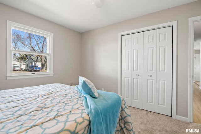 carpeted bedroom with a closet and ceiling fan