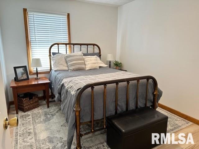 bedroom with wood finished floors and baseboards