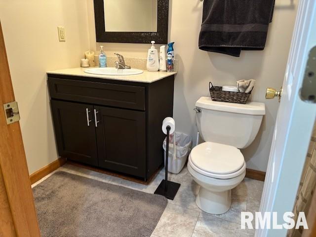 bathroom with vanity, toilet, and baseboards