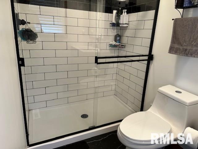 full bath with toilet and a stall shower