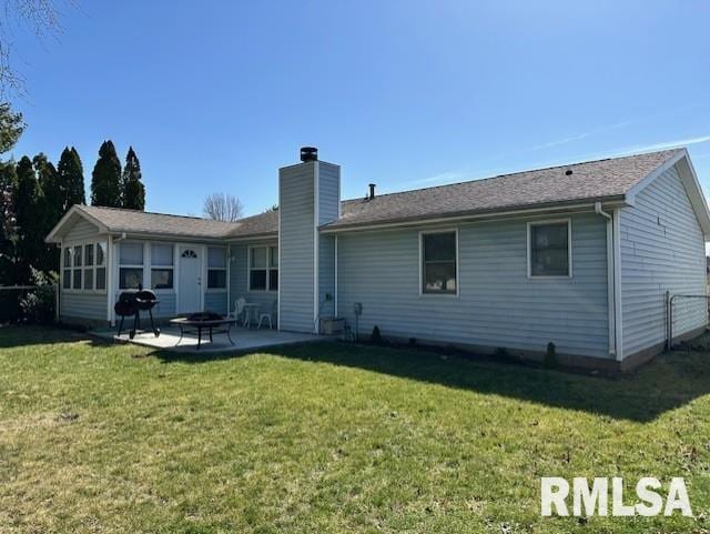 back of house featuring a yard, a patio, and a chimney