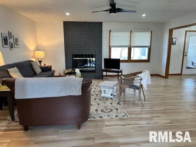 living area featuring a brick fireplace, recessed lighting, a ceiling fan, and light wood-type flooring