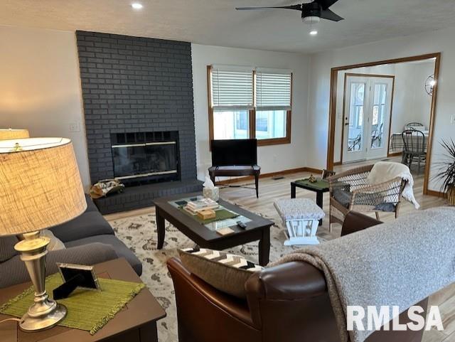 living room featuring baseboards, recessed lighting, a fireplace, wood finished floors, and a ceiling fan