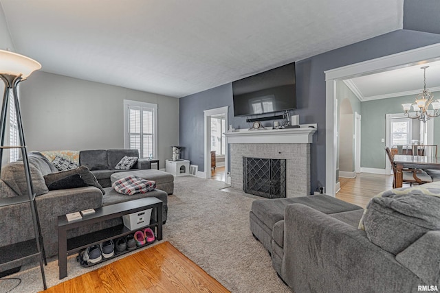 living area featuring an inviting chandelier, a healthy amount of sunlight, light wood-type flooring, and baseboards