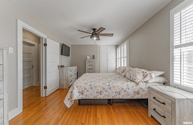 bedroom with light wood-type flooring, a closet, and ceiling fan