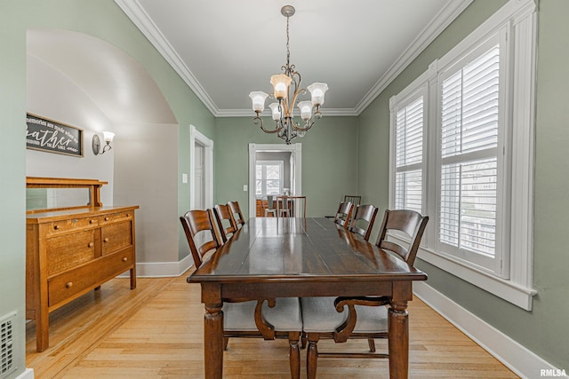 dining space with plenty of natural light, light wood-style floors, and ornamental molding