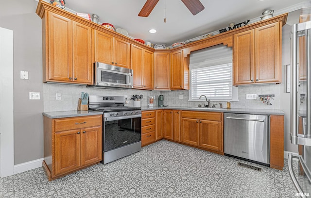 kitchen featuring a ceiling fan, a sink, appliances with stainless steel finishes, decorative backsplash, and light floors