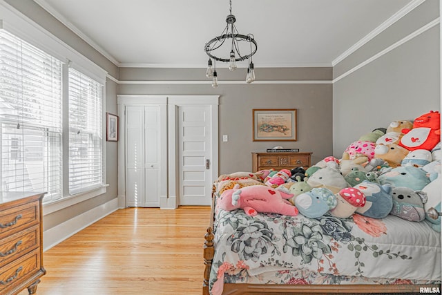 bedroom featuring a closet, wood finished floors, an inviting chandelier, and ornamental molding