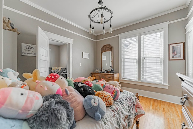 bedroom featuring crown molding, baseboards, and wood finished floors