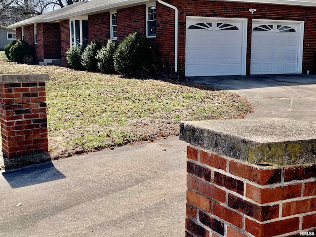 view of property exterior featuring brick siding, an attached garage, and concrete driveway