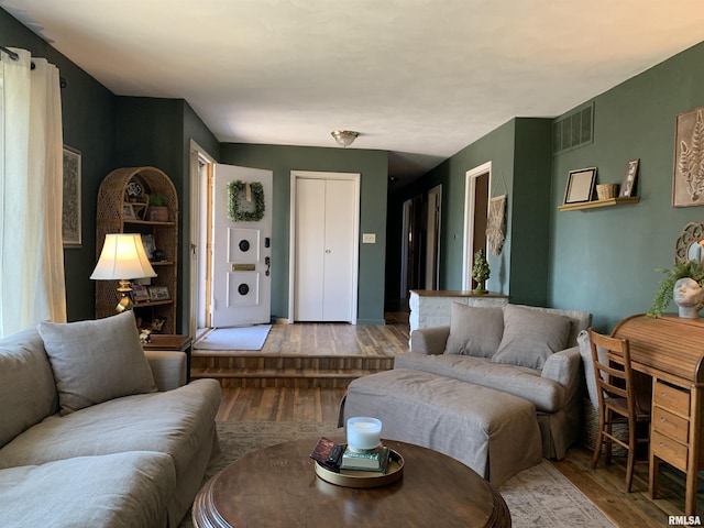 living area with visible vents and wood finished floors