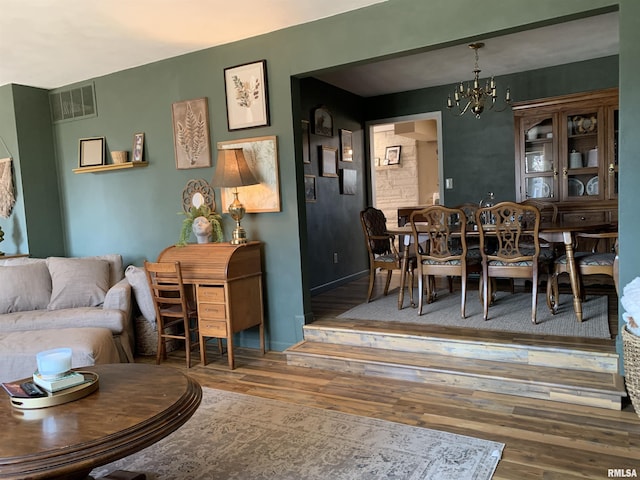 dining space with a notable chandelier, visible vents, and wood finished floors