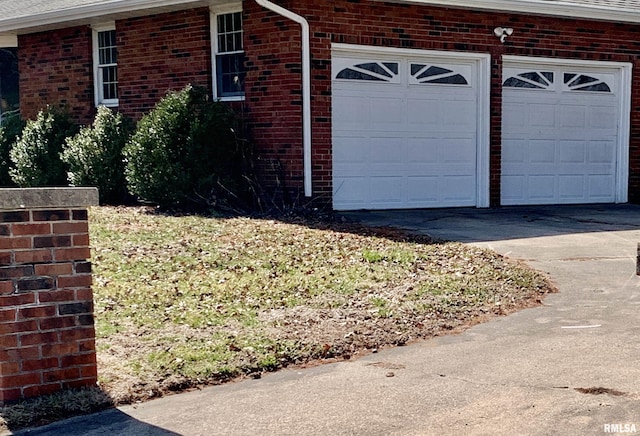 view of side of home with brick siding and driveway