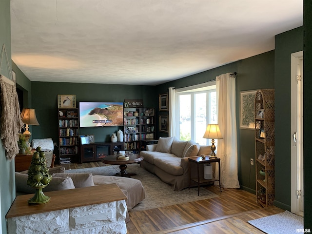 living area featuring baseboards and wood finished floors