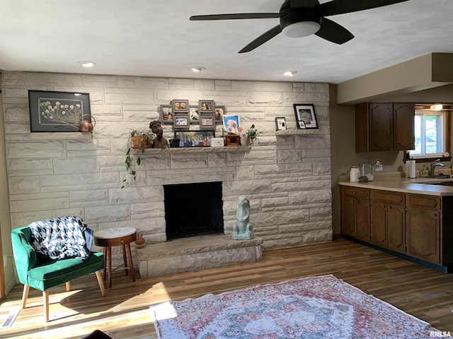 living room featuring recessed lighting, a fireplace, dark wood-type flooring, and a ceiling fan