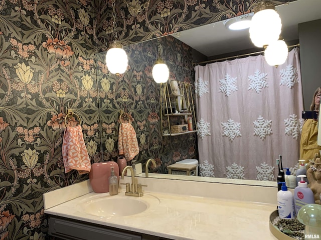 full bath with curtained shower, wallpapered walls, and vanity