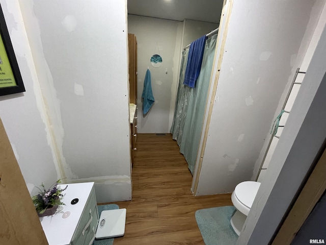 full bathroom with toilet, a shower with shower curtain, and wood finished floors