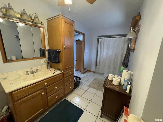 full bath with a ceiling fan, curtained shower, tile patterned flooring, baseboards, and vanity