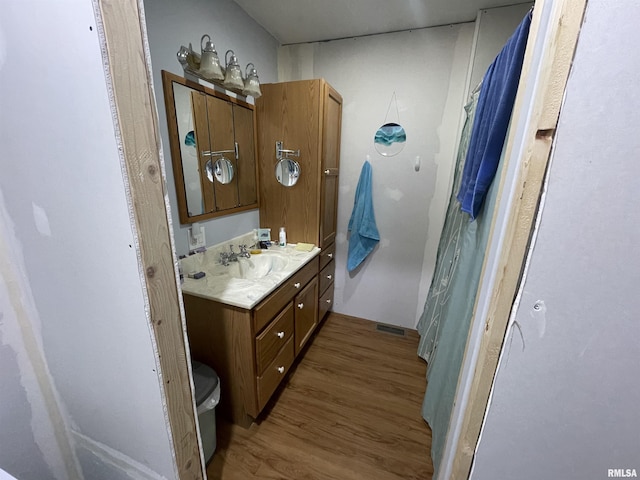 bathroom featuring toilet, wood finished floors, and vanity