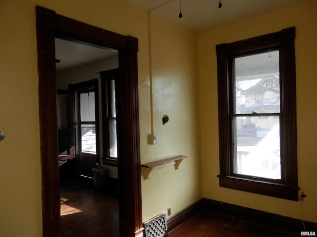 hall with dark wood-type flooring and baseboards