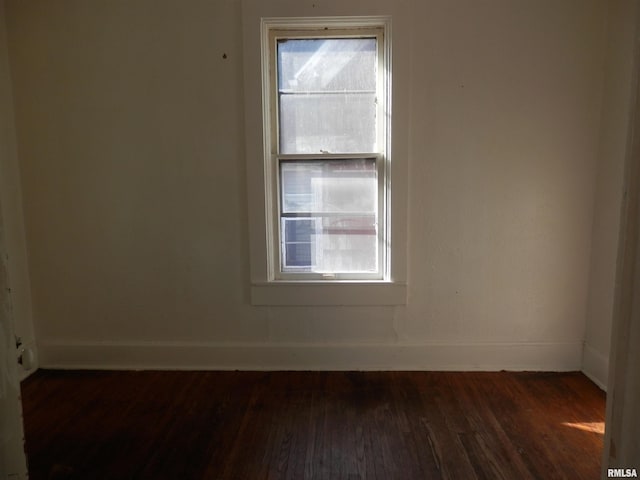 spare room with dark wood-style floors and baseboards