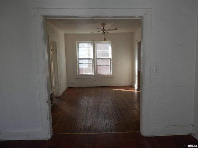 unfurnished room with baseboards, wood-type flooring, and a ceiling fan