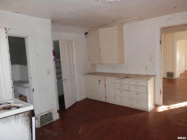 kitchen with visible vents, dark wood-style flooring, and light countertops