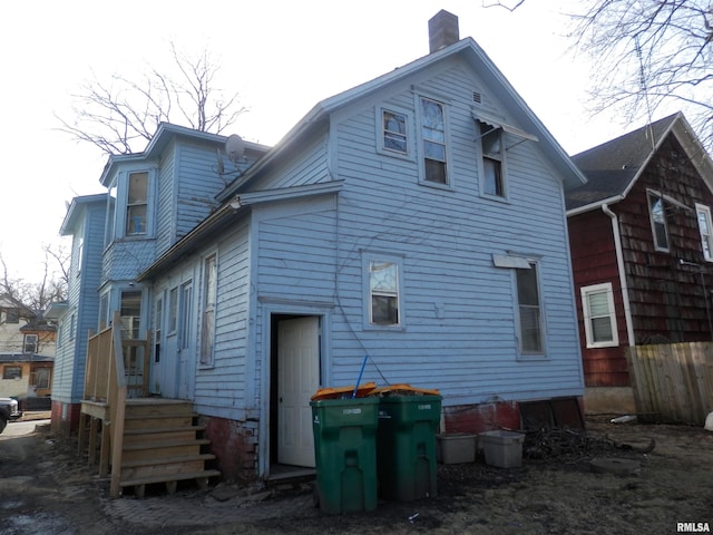 back of house with a chimney