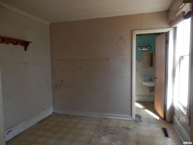 unfurnished room featuring tile patterned floors, visible vents, plenty of natural light, and crown molding