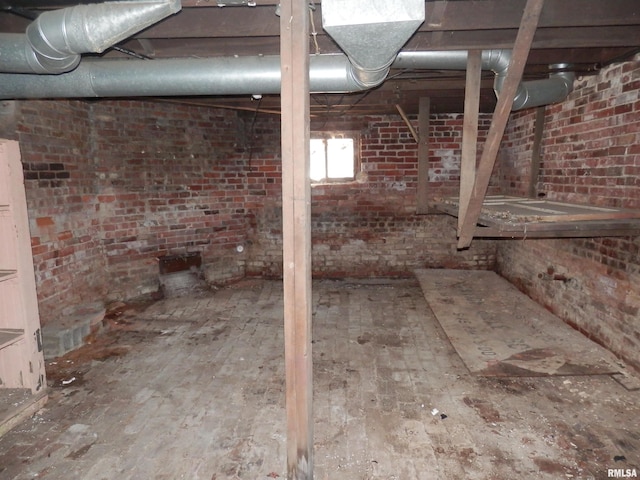 unfinished basement featuring brick wall