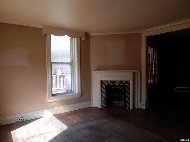 unfurnished living room with baseboards, wood finished floors, a fireplace, and ornamental molding