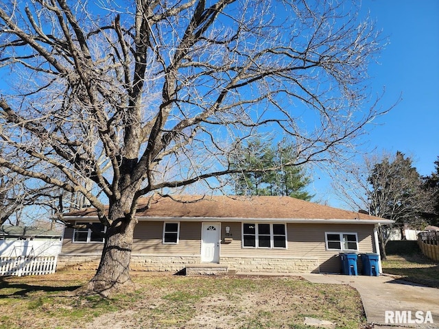 ranch-style home featuring a front lawn and fence